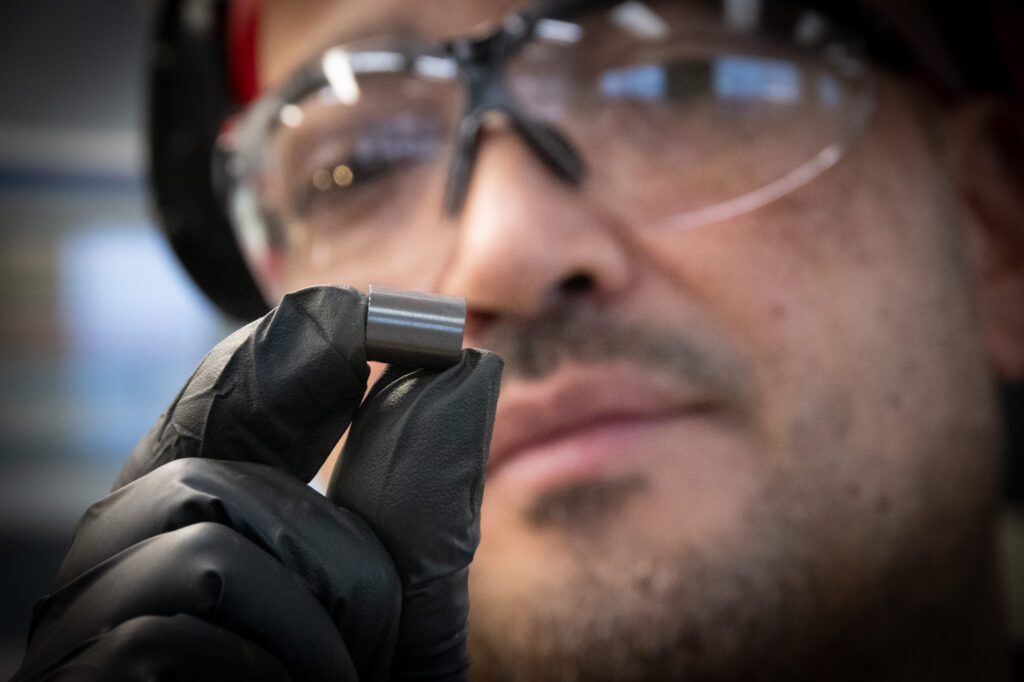 BWXT NEC employee holding a CANDU uranium fuel pellet.