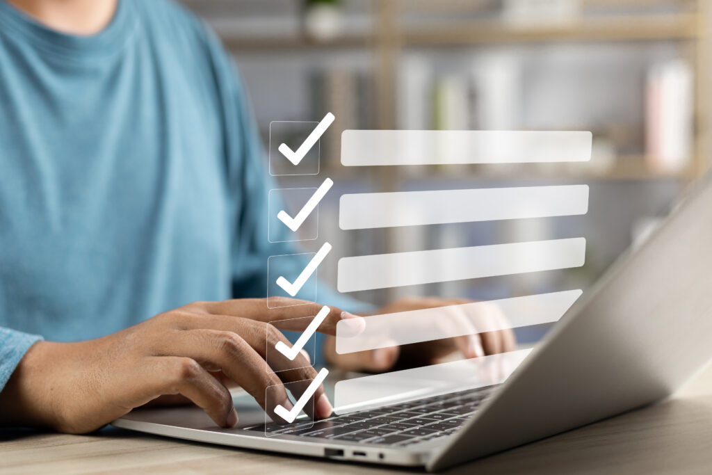 BWXT nuclear energy canada Business performance monitoring and evaluation concept, Take an assessment, Business man using laptop and tablet online checklist survey, Filling out digital checklist, Questionnaire with checkboxes.