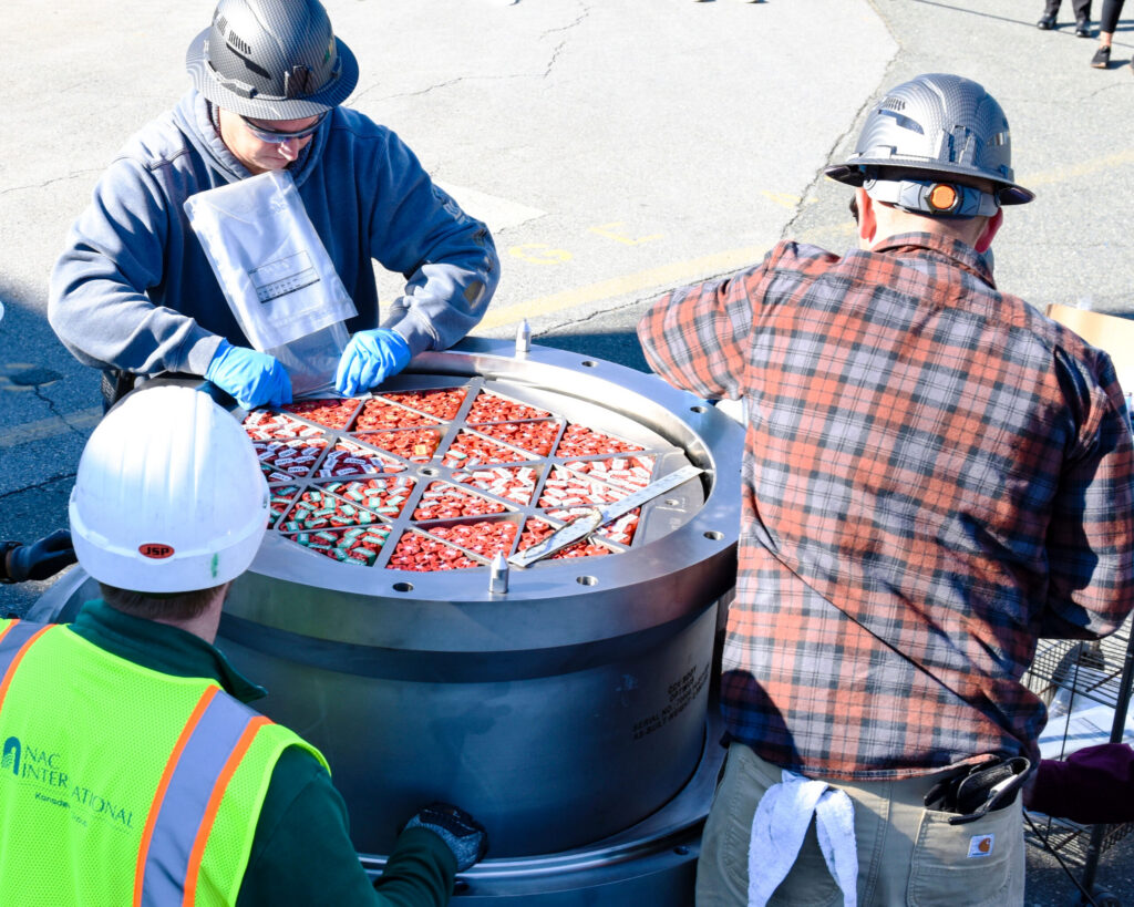 BWXT PELE fuel being prepared by 3 employees with the BWXT logo on top
