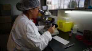 BWXT scientist employee white lab coat microscope